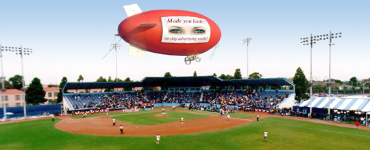 Coke a Cola and Bud Light blimps over ice rink.